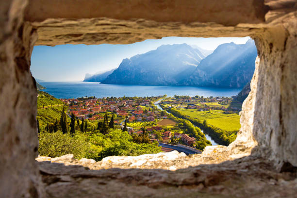 miasto torbole i lago di garda widok zachodu słońca przez kamienne okno - prowincja trydent zdjęcia i obrazy z banku zdjęć