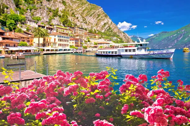 Tourist boat in Limone sul Garda picturesque harbor, Garda lake in Lombardy region of Italy