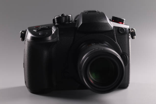 istock Closeup of black professional camera on gray background 1358654167