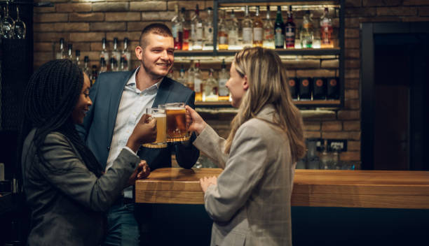 istock Cheerful colleagues drinking beer in the bar together after work 1358654209