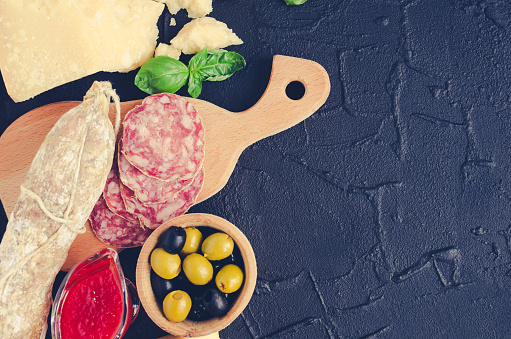 Mediterranean appetizers, tapas or antipasti. Assorted Italian traditional products food set. Delicious snack on party. Chopping board with meat and cheese. Top view. Copy space.