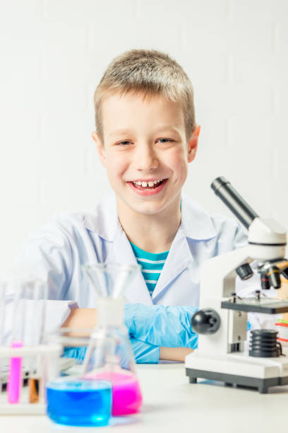 istock A schoolboy with a microscope examines chemicals in test tubes, conducts experiments - a portrait on a white background. Concept for the study of coronavirus in the laboratory 1358655346