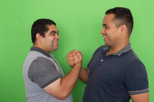 istock Two men greeting each other, on a green screen background (chroma-key) 1358661374