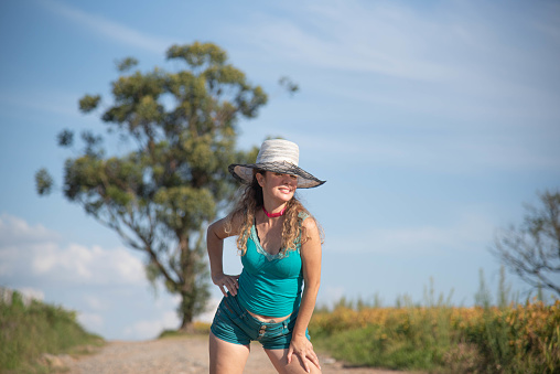 Blonde Brazilian woman posing for photos in rural landscape. Young girl wearing blue. Photographic model. Country photography. area of farms in Brazil. photography of people. Pretty Woman.