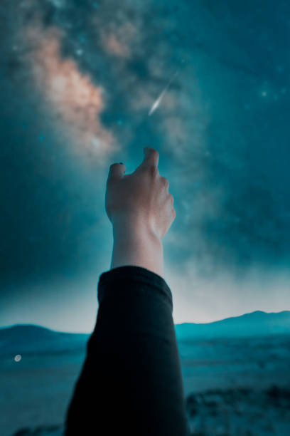 istock hand view, hand pointing or touching the starry sky with Milky Way and shooting star 1358667596