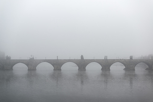 Foggy morning twilight on the famous Charles Bridges in the Czech Republic - the city of Prague