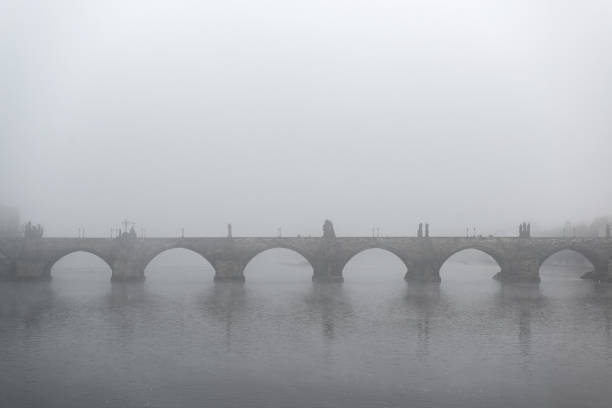 crepúsculo da manhã nebuloso nas famosas pontes charles na república tcheca - a cidade de praga - fog old stone bridge - fotografias e filmes do acervo