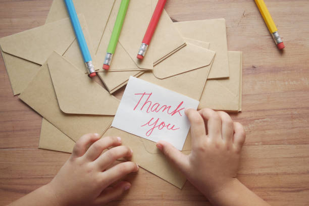 istock child hand holding thank you letter on table 1358670771