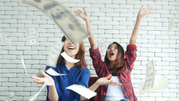 Happy young asian woman holding dollar money and throw in the air celebrate happiness dance wealth lottery money rain drop. Winner Success business woman throw cash flow Happy money smiling face stock photo