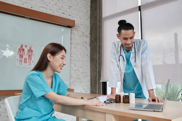istock Two uniformed young doctors work in medical clinic office. 1358676343