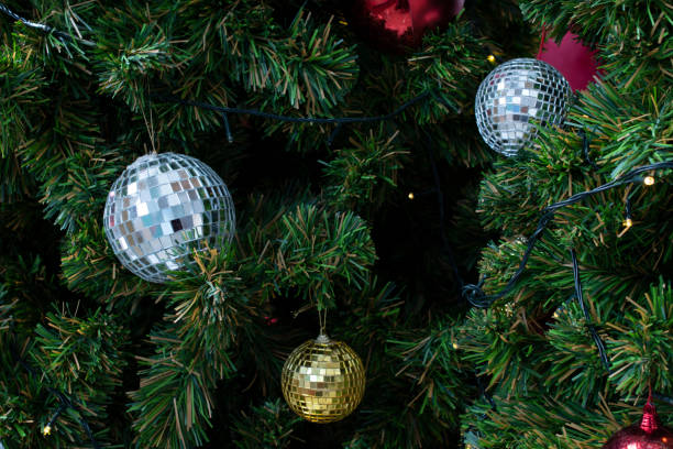 istock Shiny mirror disco style christmas ball on christmas tree with LED light 1358678077