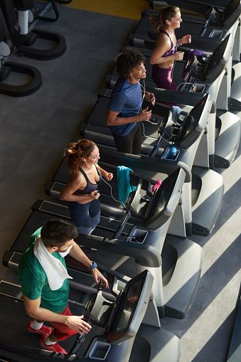 People running on a treadmills in health club