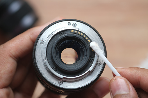 close up of cleaning camera lens .