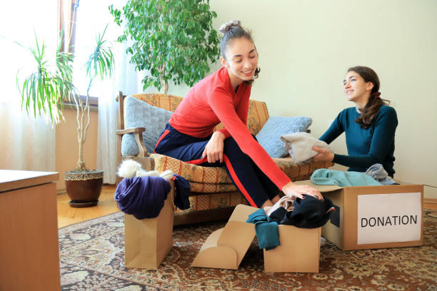 istock Two girls packing clothes for donation 1358699464