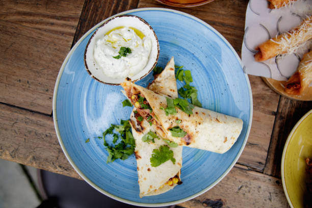 Burritos with cream in bowl on the side