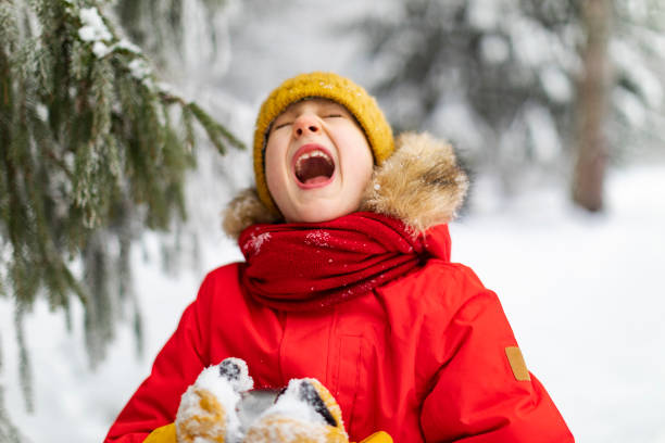 istock Little boy having fun in winter forest 1358700910
