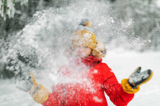 istock Little boy having fun in winter forest 1358700923