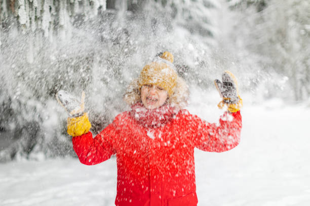 istock Little boy having fun in winter forest 1358700936