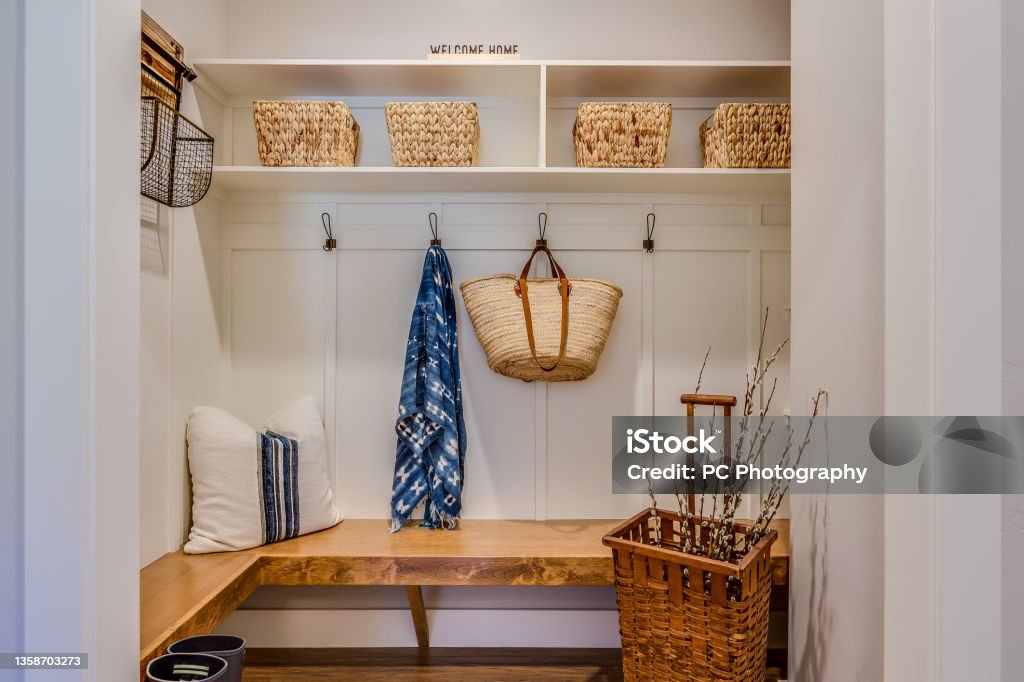 Cozy mudroom nook Natural wood bench and cubbies with baskets is a designer's dream Mudroom Stock Photo