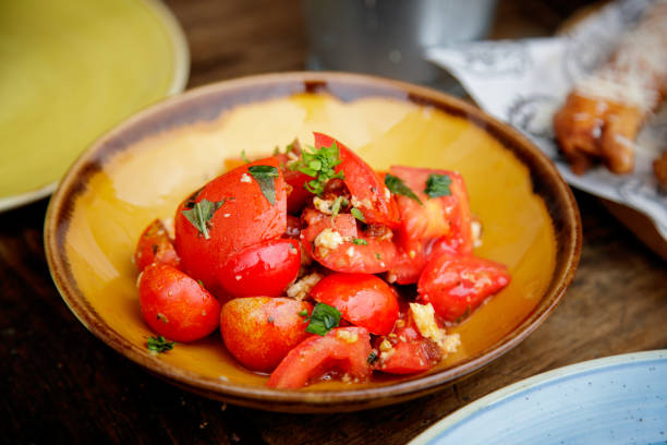 istock Cherry tomato with garlic, basil and parsley in plate 1358704155