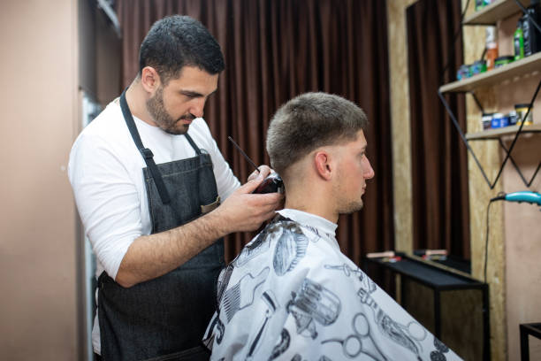 istock Barber doing fade haircut to a young  guy 1358704346