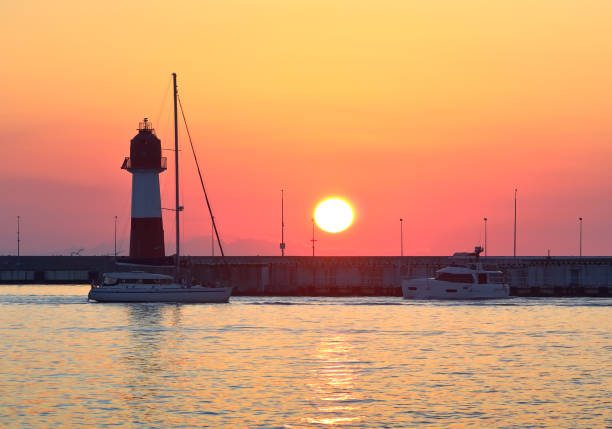 Sunset at the Sochi lighthouse Sunset at the Sochi lighthouse. Yachts in the water area at the sea station on the Black Sea coast sochi photos stock pictures, royalty-free photos & images
