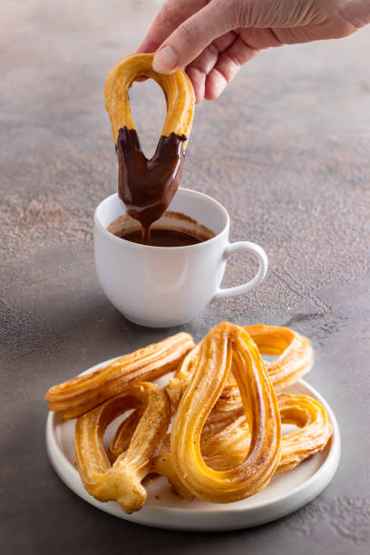 los churros, bocadillo típico español como es una masa frita. los churros son un desayuno clásico español consumido con chocolate caliente - churro chocolate cup sweet food fotografías e imágenes de stock