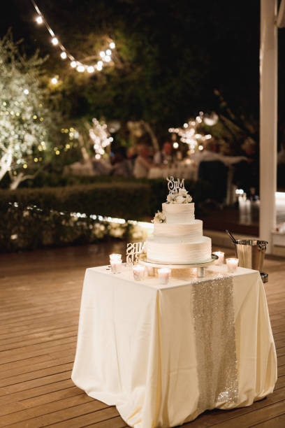 Three-tiered wedding cake decorated with flowers on a table with a tablecloth