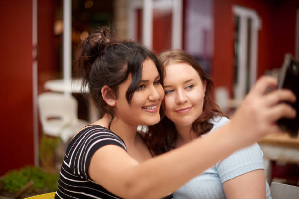 istock Shot of two friends taking selfies together while at a restaurant 1358713374