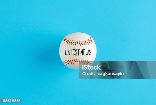 istock Baseball ball on blue background with the word latest news. 1358715556