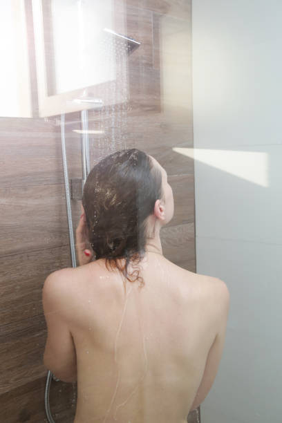 istock Young beautiful woman taking shower in bathroom 1358717260
