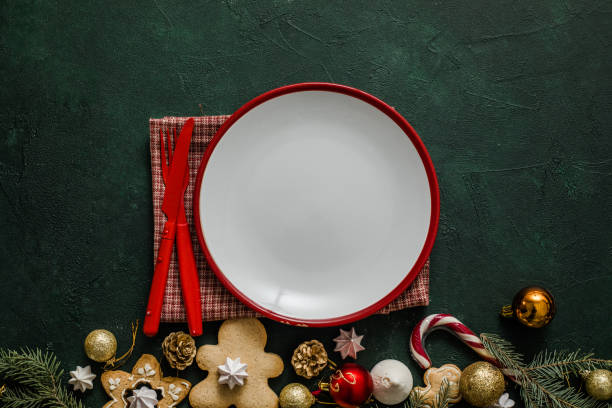 istock Christmas and New year setting table. White empty plate with cutlery and Christmas tree branches, red napkin on a red concrete background. 1358719808