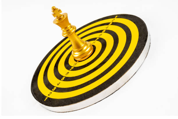 rei dourado no jogo de xadrez de batalha fica no centro da prancha de dardos - dartboard target bulls eye sport - fotografias e filmes do acervo