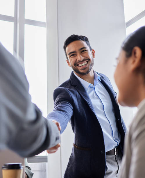 photo de deux hommes d’affaires se serrant la main lors d’une réunion - handshake business business person communication photos et images de collection