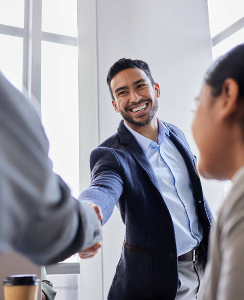 shot of two business people shaking hands during a meeting - interview evenement stockfoto's en -beelden