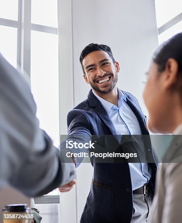 istock Shot of two business people shaking hands during a meeting 1358724438