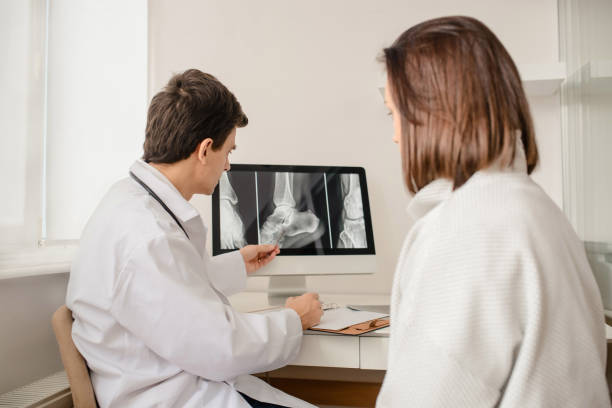 Young man doctor explain to the woman patient Young man doctor explain to the woman patient the result of x ray that show fracture of her calcaneus tibia photos stock pictures, royalty-free photos & images