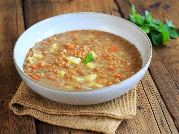 hearty homemade lentil soup on a white plate stock photo