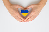 Die Nationalflagge der Ukraine in weiblichen Händen. Das Konzept des Patriotismus, des Respekts und der Solidarität mit den Bürgern der Ukraine