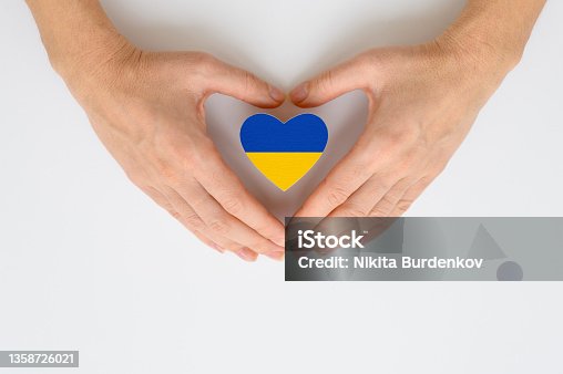 istock The national flag of Ukraine in female hands. The concept of patriotism, respect and solidarity with the citizens of Ukraine 1358726021