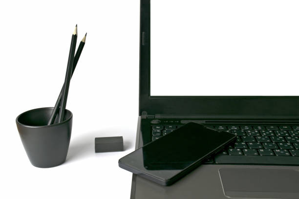 istock Notebook computer,smartphone,,Eraser and pencil in black glass on white background. 1358727388