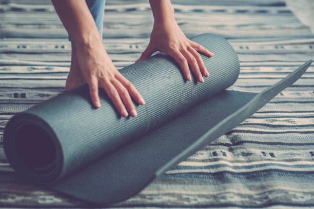 istock Cropped Hands Of Woman Rolling Exercise Mat 1358728375