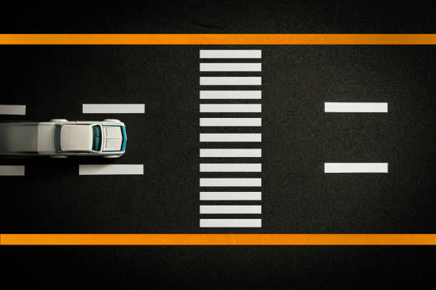 istock Top view of tiny model car speeding on black highway with crosswalk 1358730143