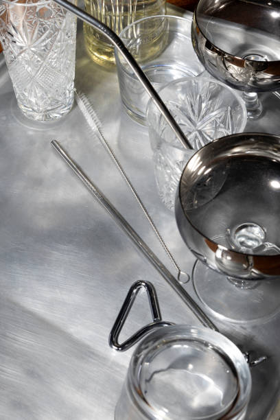 istock Vertical image of old fashioned glasses,metallic cocktail sticks,bottle on the silver tray.Empty space 1358731576