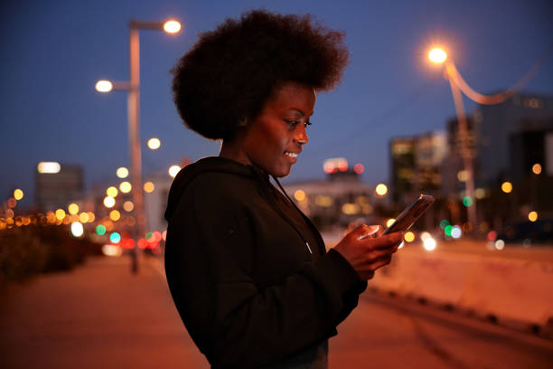 istock A woman is using a smartphone outdoors. 1358734330