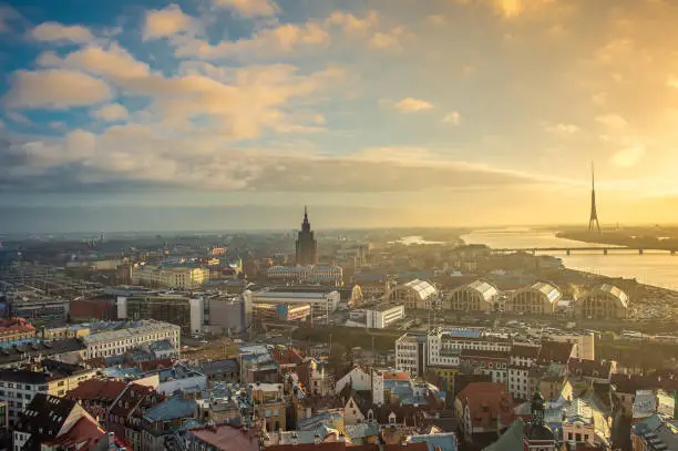 Panorama of the city of Riga on a sunny day, blue sky, morning, sunset, a view of the old town, narrow streets, red brick roofs of houses, a river and bridge. Can be used for websites, brochures, posters, printing and design.
