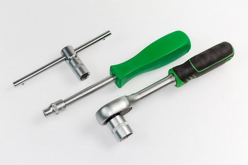 Ratchet wrench, nut driver and T-handle with inserted hexagonal sockets different sizes with metric marking on a light surface