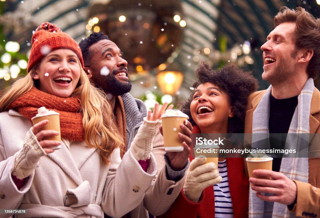 Group Of Friends Drinking Hot Chocolate With Marshmallows In Snow At Outdoor Christmas Market Christmas Market Stock Photo
