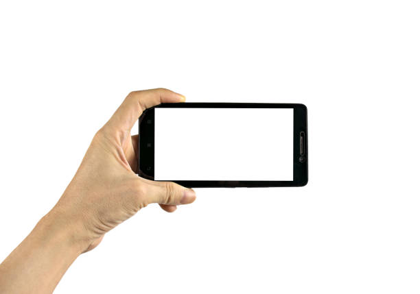 istock Hand holding black smartphone isolated on white background with clipping path. 1358735825
