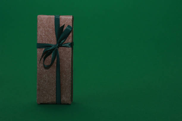istock Brown gift box with a bow on a green paper background. 1358736380